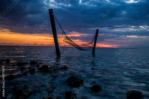 hamac suspendu dans l'ocean couché de soleil photo