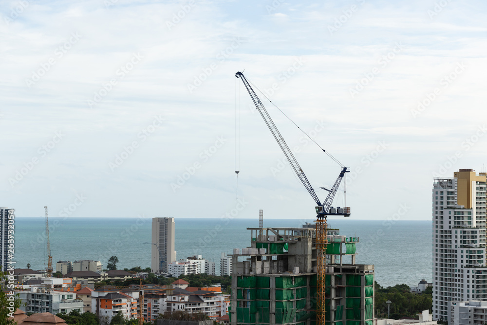 Construction high-rise building by construction crane.