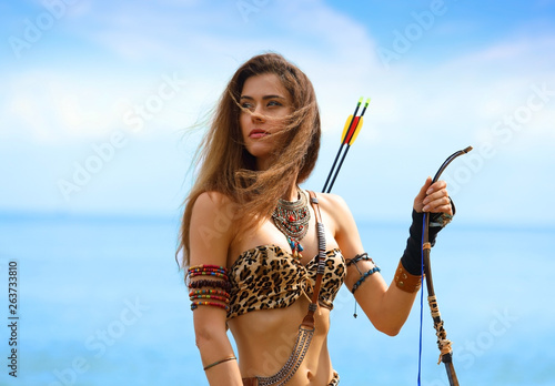 Portrait of a young beautiful girl with a bow and arrows