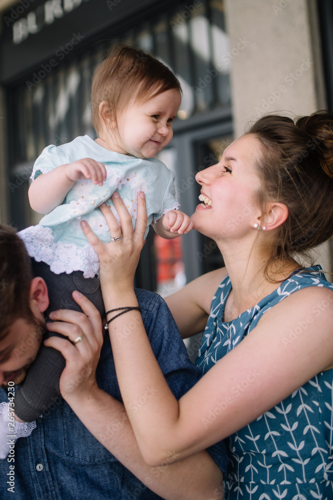Mum putting child on fathers shoulders Mum putting child on fathers shoulders