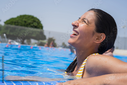 Young indian woman laughing and happy in the pool