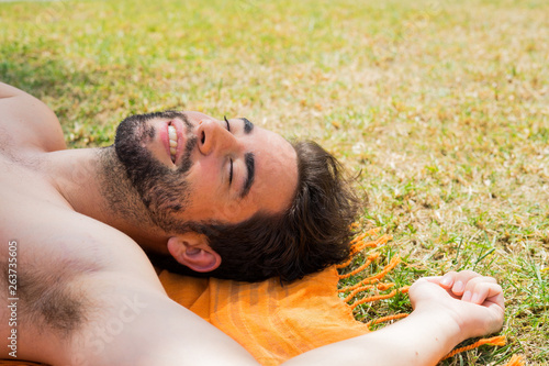 young man sunbathing in the pool