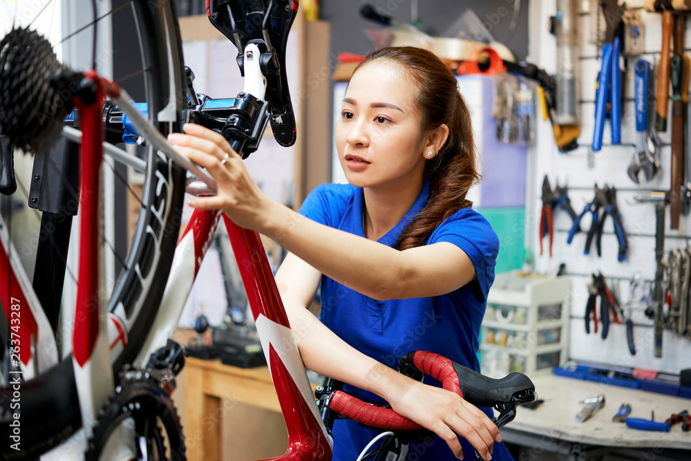 Fototapeta premium Woman in biking repair shop