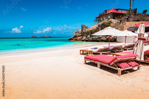Fototapeta Naklejka Na Ścianę i Meble -  Luxury beach chairs and umbrella on exotic beach in St Barths, Caribbean Island.