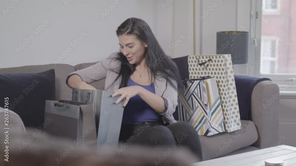 A Young Attractive Lady Looks Through Shopping Bags And Is Really Happy About The Things She Has Purchased, In Slow Motion - Ungraded A Young Attractive Lady Looks Through Shopping Bags And Is Really Happy About The Things She Has Purchased, In Slow Motion - Ungraded