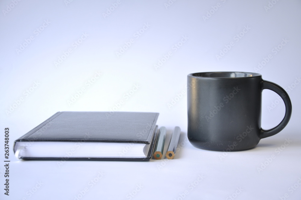 cup of coffee and notebook on table cup of coffee and notebook on table