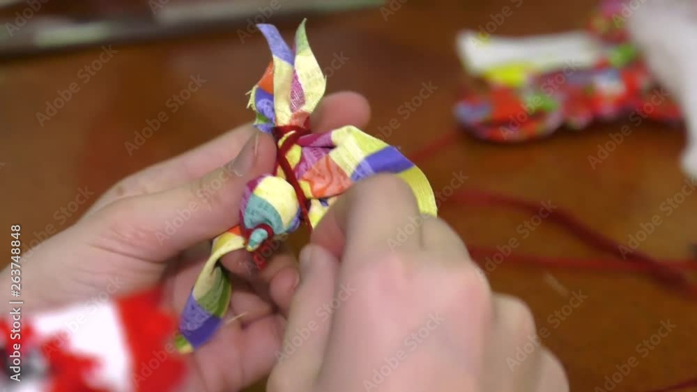 Bird made of cloth is a folk rag hand-made article. Folk toy - bird fabric. The rite of meeting the spring and incoming birds. The girl wraps a toy. Bird made of cloth is a folk rag hand-made article. Folk toy - bird fabric. The rite of meeting the spring and incoming birds. The girl wraps a toy.