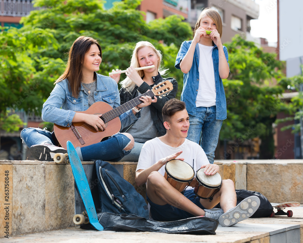 Teenagers playing music outdoors  .