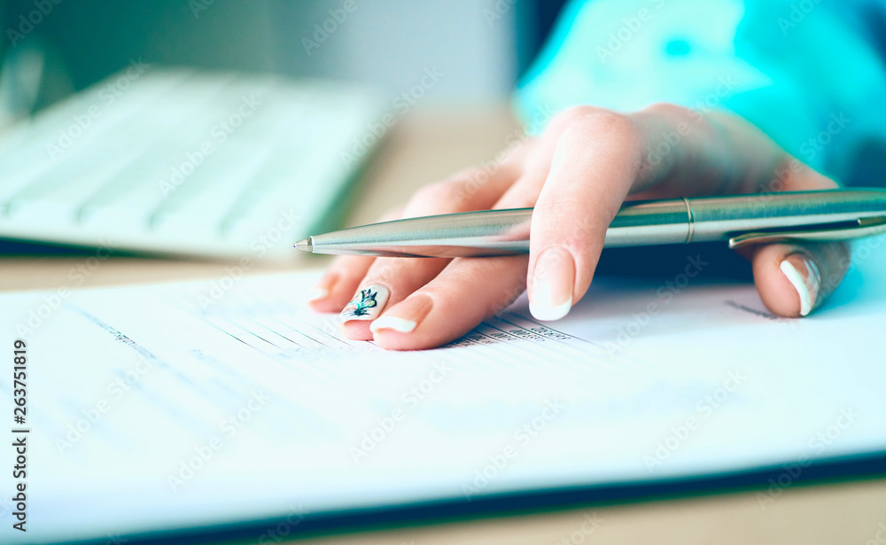 Hand of businesswoman filling and signing with silver pen partnership agreement form clipped to pad close-up. Management training course, some important document, team leader ambition concept. Hand of businesswoman filling and signing with silver pen partnership agreement form clipped to pad close-up. Management training course, some important document, team leader ambition concept.