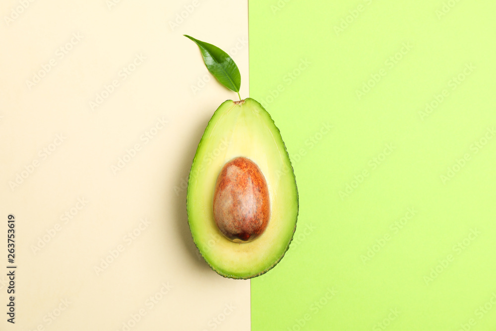 Rip cut avocado with leaf on two tone background, space for text