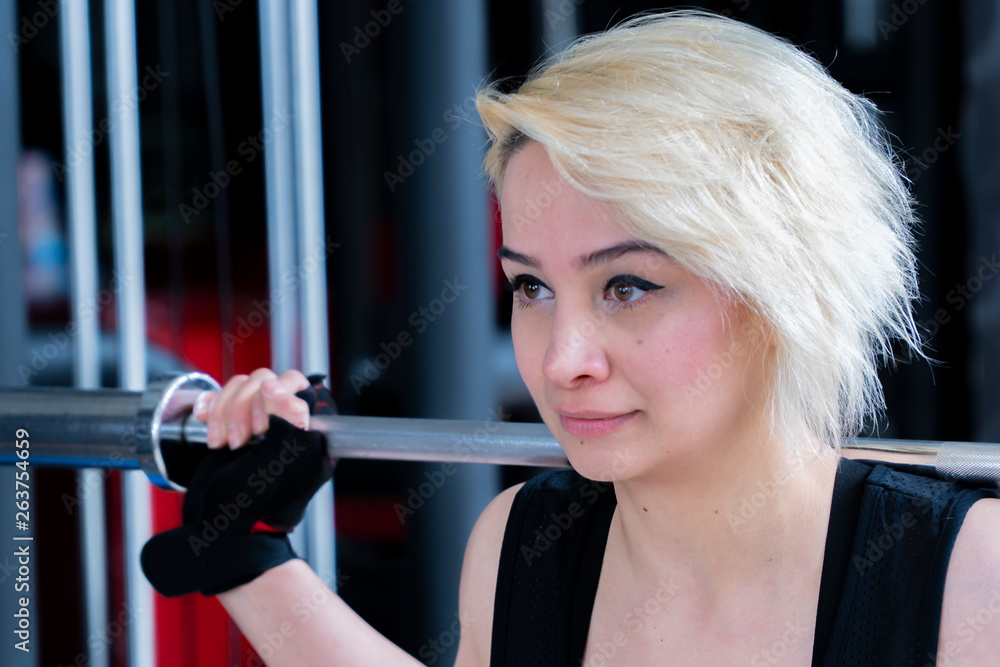 Obraz premium Beautiful blonde girl working at the gym center