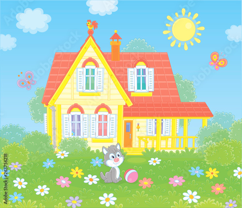 Village house and a small grey kitten playing with butterflies among flowers on green grass of a lawn, vector illustration in a cartoon style