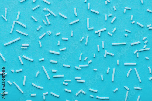 top view of blue sprinkles over blue background, decoration for cake and bakery