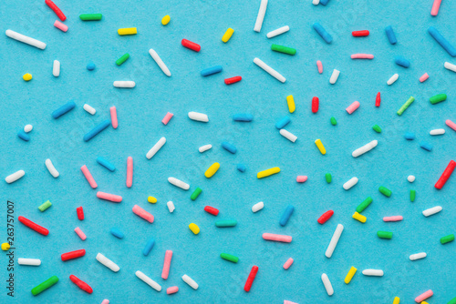 colorful sprinkles over blue background, decoration for cake and bakery