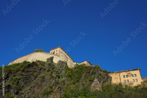 Blauer Himmel und Teilansicht der Festung Ehrenbreitstein bei Koblenz an Rhein und Mosel mit Felsen und Mauerwerk - Stockfoto