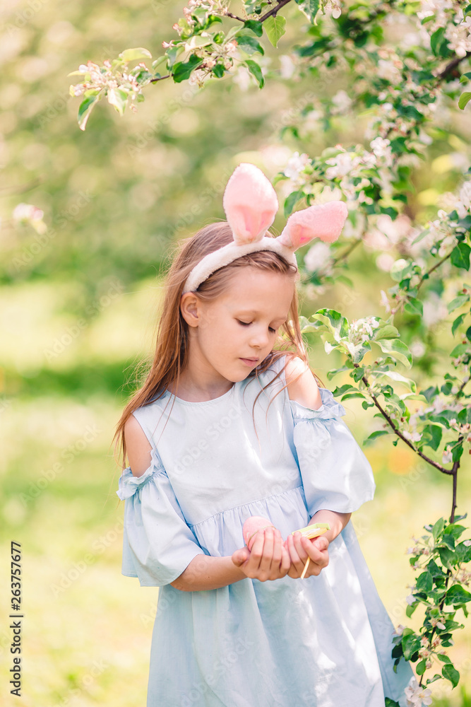 Adorable little girl in blooming apple garden on beautiful spring day Adorable little girl in blooming apple garden on beautiful spring day