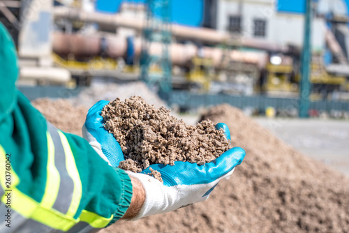 Wall Mural Man holding shredded paper in front of rotary cement kiln used as alternative fu