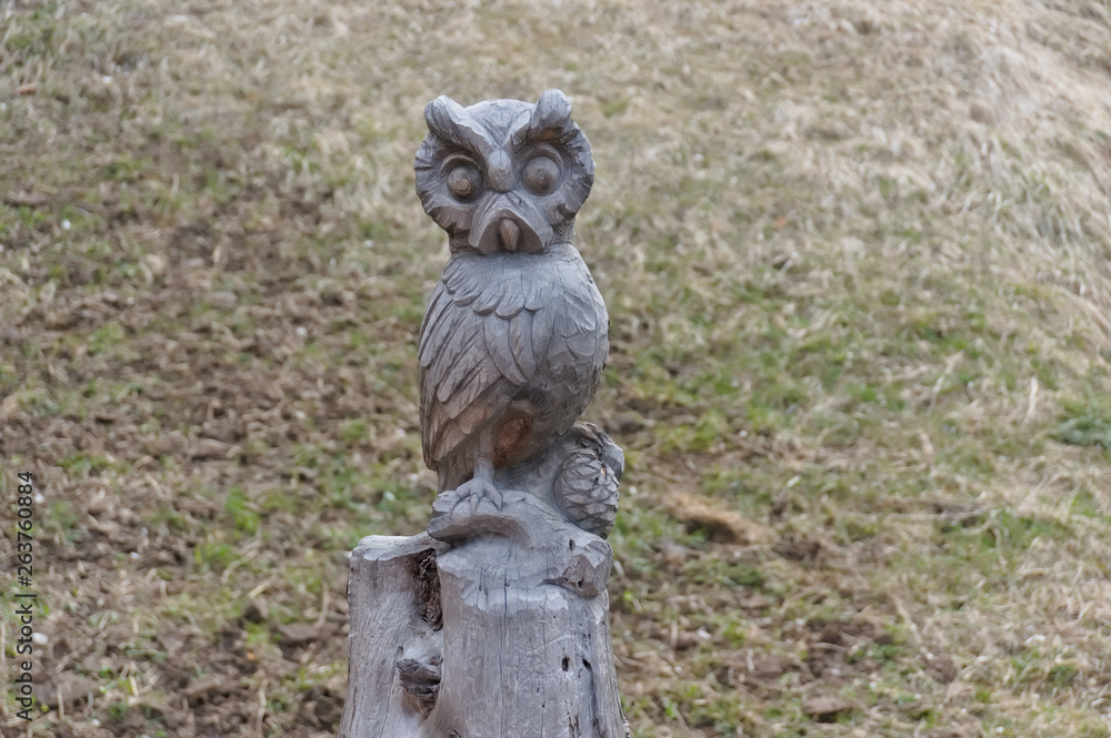 Owl carved from wood on a hiking path in val gardena Owl carved from wood on a hiking path in val gardena