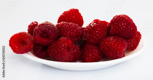 Image  of ripe red fresh  raspberries on white surface