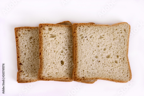 Three slices of white bread on a light table.