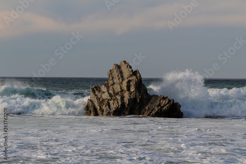 rock in the sea, which is hit by the waves. On the beach of Atxabiribil in Sopelana
