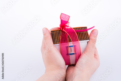 Hand holding a house with a ribbon photo