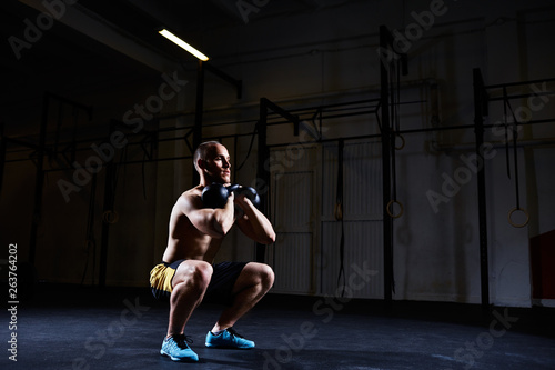 Athlete doing squat with kettlebells