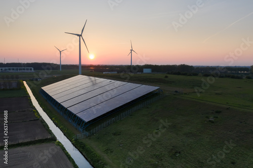 Wind turbines and solar panels generating green energy during sunset as seen from above in Waalwijk, Noord Brabant, Netherlands