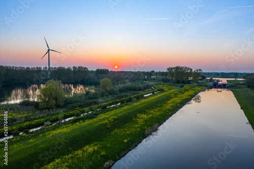 Wind turbines generating green energy during sunset as seen from above in Waalwijk, Noord Brabant, Netherlands