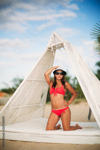 Beautiful girl on the coast in a hut. Sexy lady in pink swimsuit © Aleksandr