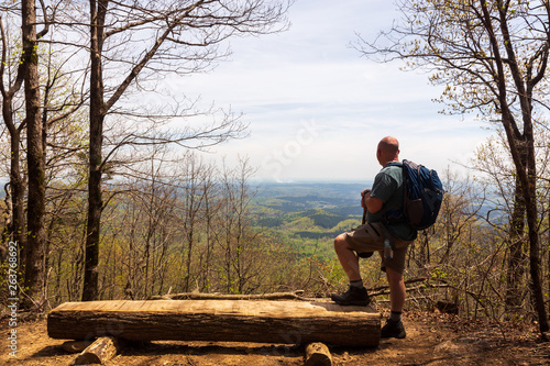 HIker on a mountain trail at overlook viewing the Blue Ridge Mountains in the Chattahoochee National Forest.