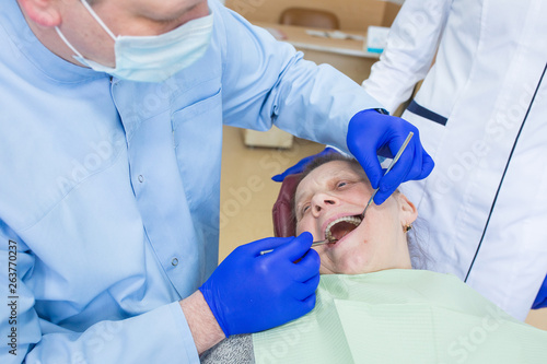 Elderly woman sits in a dental chair as a patient. People health care, dentistry, medicine concept. Doctor and patient. Teeth dentist with patient in hospital Description