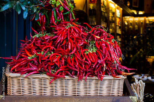 Bunch of red hot chili peppers in a straw basket on the market of Palma de Mallorca in Spain.