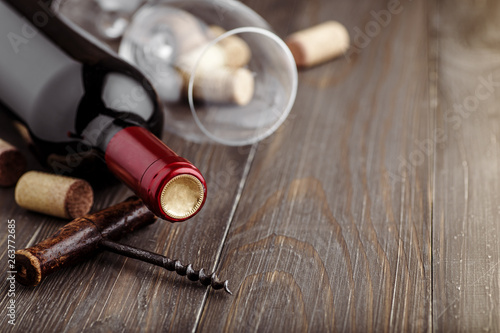 Glass bottle of wine with corks on wooden table background.Top view with copy space