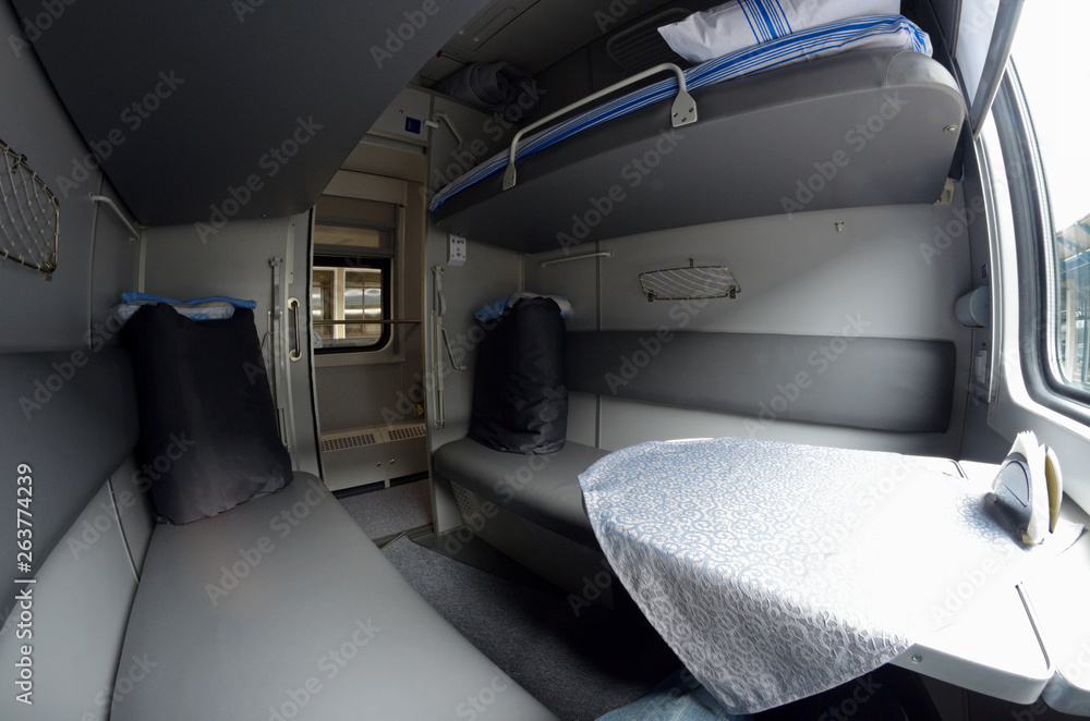Fototapeta premium Compartment and berth with bed-linen packages in Ukrainian Railways First Class sleeping carriage of a passenger train
