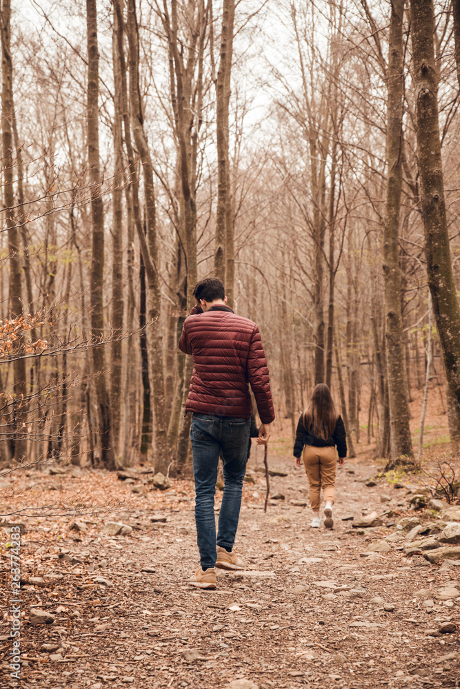 Man and girl walking through forest in autumn Man and girl walking through forest in autumn