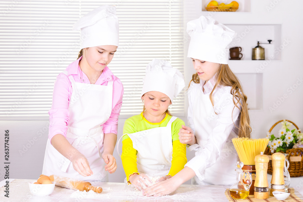 Portrait of three cute girls cooking on kitchen Portrait of three cute girls cooking on kitchen