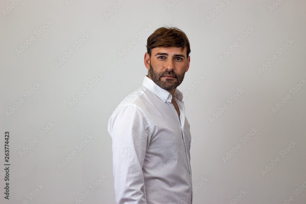 Obraz premium Fashion portrait of handsome young man with brown hair in love, their back facing the camera and looking at the camera. Isolated on white background.