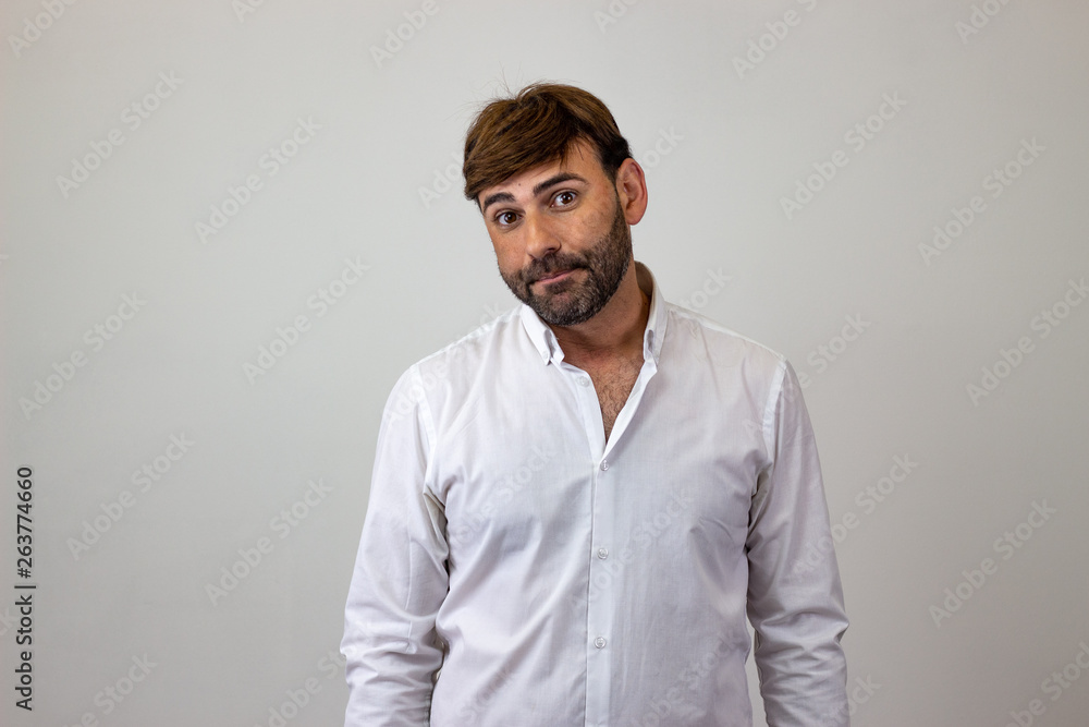 Fashion portrait of handsome young man with brown hair and a look of disgust, looking at the camera. Isolated on white background. Fashion portrait of handsome young man with brown hair and a look of disgust, looking at the camera. Isolated on white background.