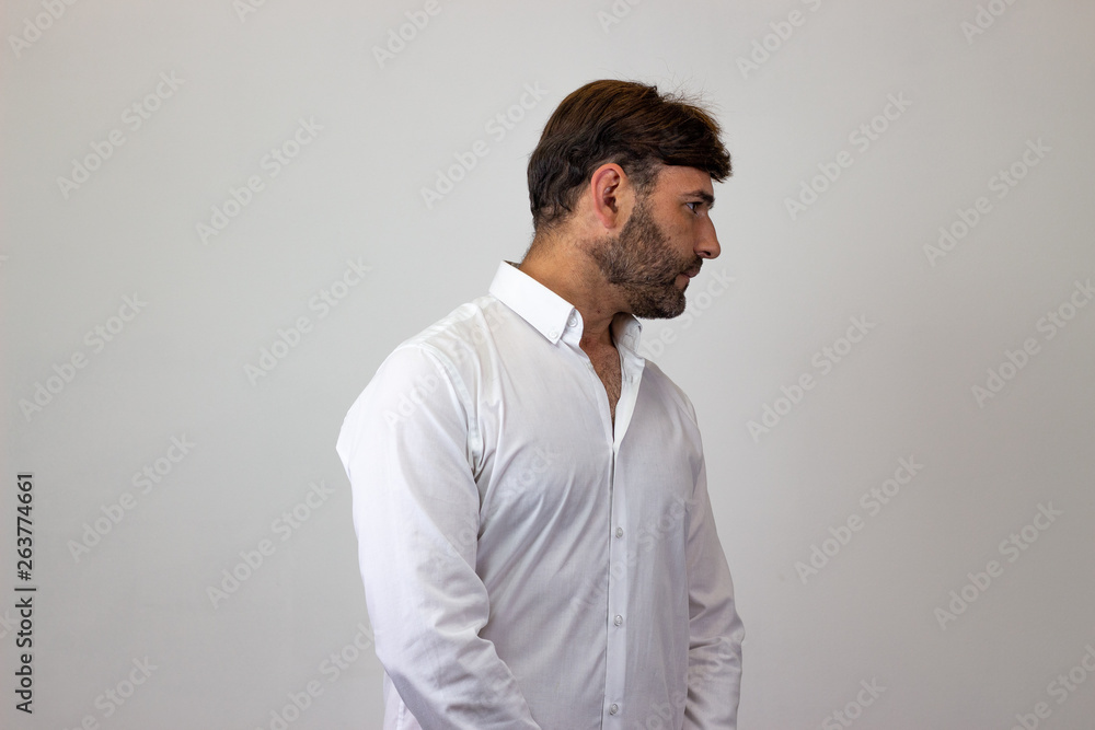 Fashion portrait of handsome young man with brown hair and a look of disgust, facing forwards and looking at the side. Isolated on white background. Fashion portrait of handsome young man with brown hair and a look of disgust, facing forwards and looking at the side. Isolated on white background.