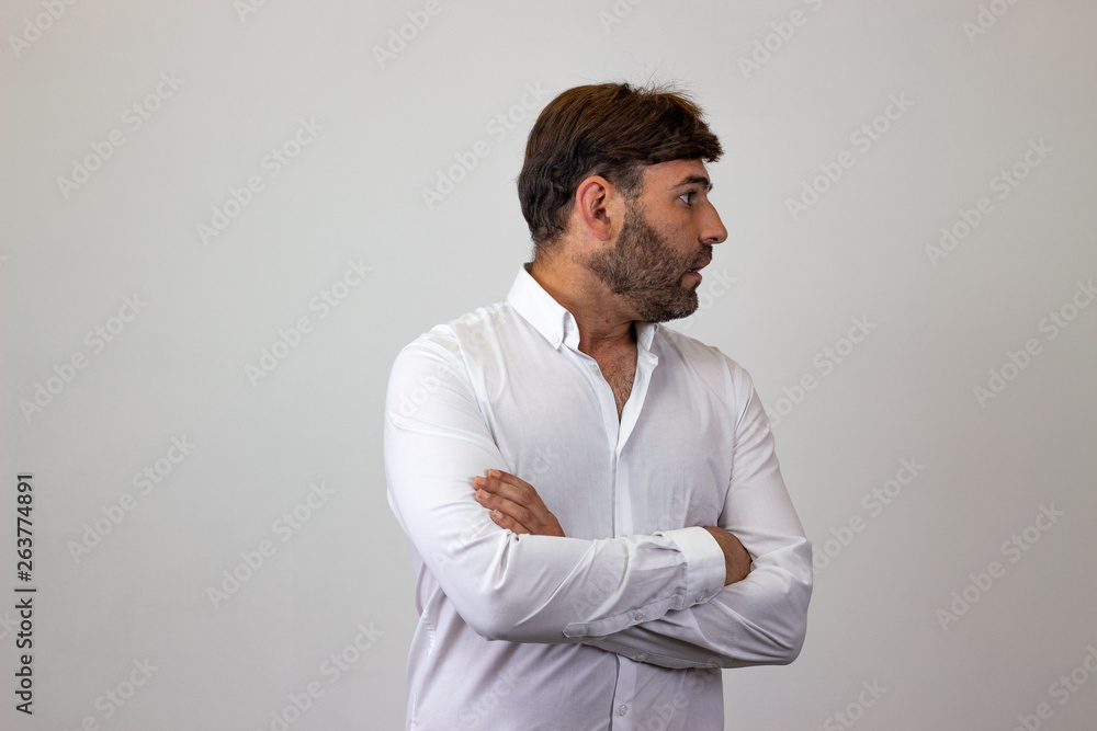 Fashion portrait of handsome young man with brown hair looking scared, facing forwards and looking at the side. Isolated on white background. Fashion portrait of handsome young man with brown hair looking scared, facing forwards and looking at the side. Isolated on white background.