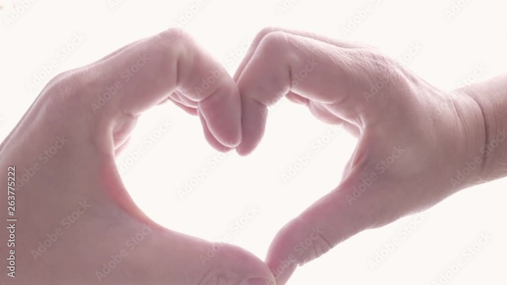 Bright washed out view of hands making heart shape Bright washed out view of hands making heart shape