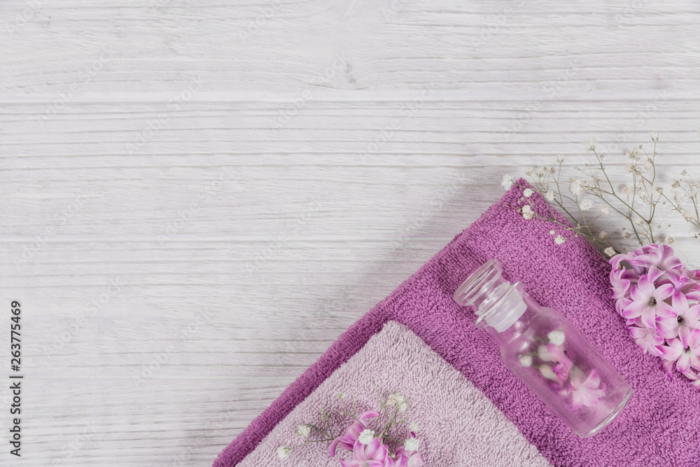 Abstract composition of pink hyacinths flowers, towels and bottles of organic cosmetic with essential oil Abstract composition of pink hyacinths flowers, towels and bottles of organic cosmetic with essential oil