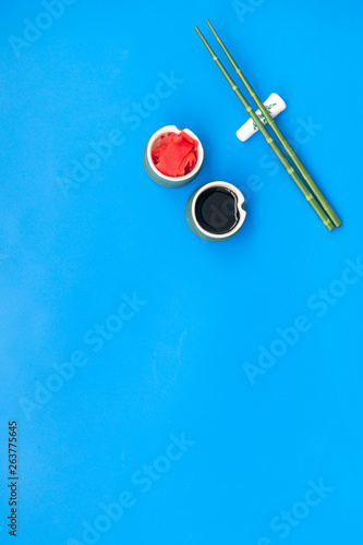 bamboo sticks, soy sauce, ginger for sushi and maki on blue background top view mockup