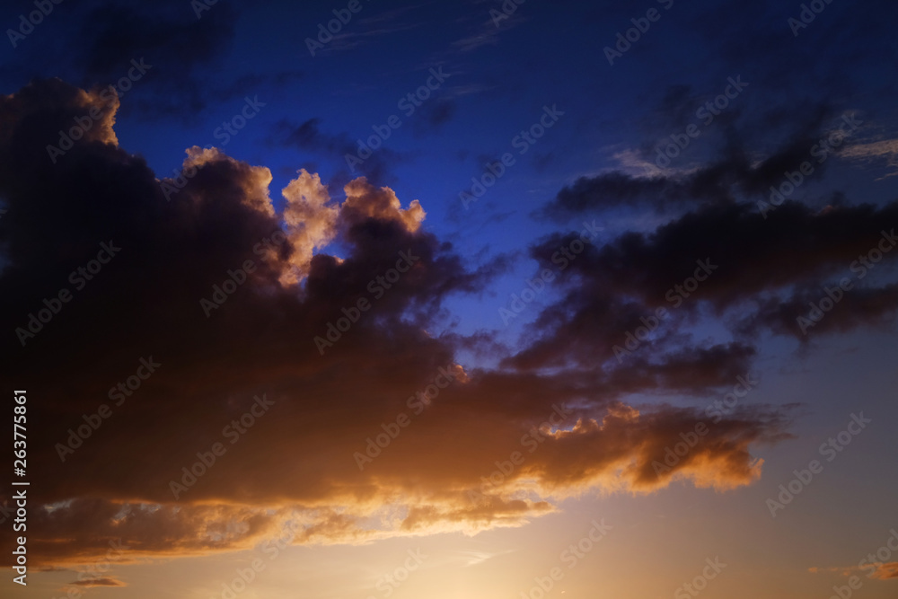 Golden sunlight and fluffy orange cloud on the blue sky an evening time