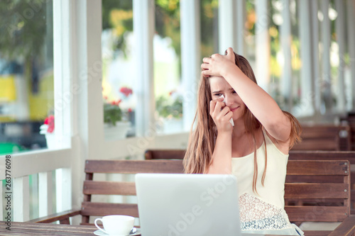 Woman in front of computer crying having a video chat.