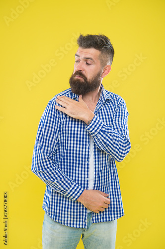 Shake it off. Summer hipster. Brutal bearded hipster in checkered shirt brush dust off shoulder. Male fashion. Pedantic man with beard on yellow backdrop. Mature man. Everything must be perfect photo