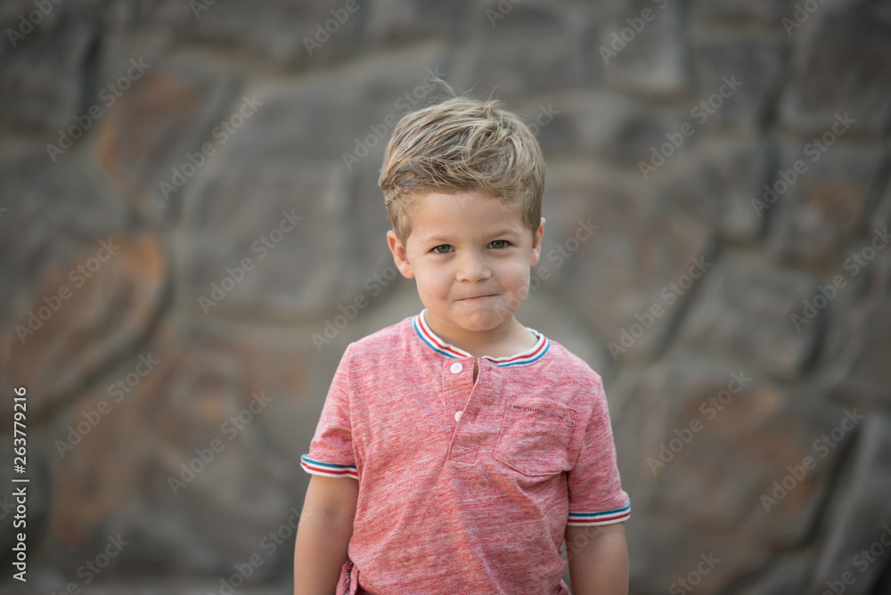 Portrait of Young Boy With Simple Rock Wall Background Portrait of Young Boy With Simple Rock Wall Background
