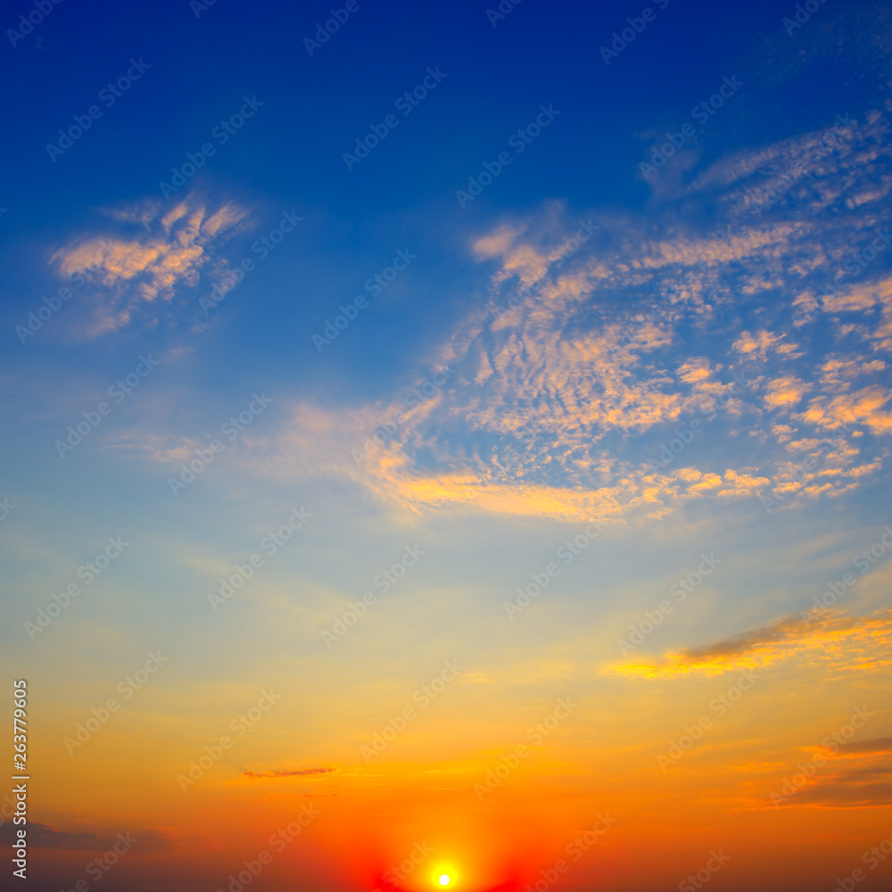 Scenic sunset on background bright blue sky and clouds