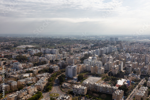 Aerial view of a residential neighborhood in a city during a cloudy and sunny sunrise. Taken in Netanya  Center District  Israel.